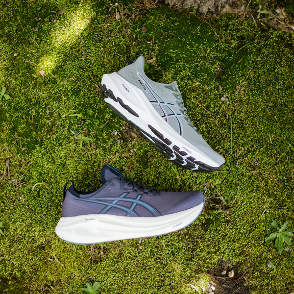 Two running shoes on a green mossy surface